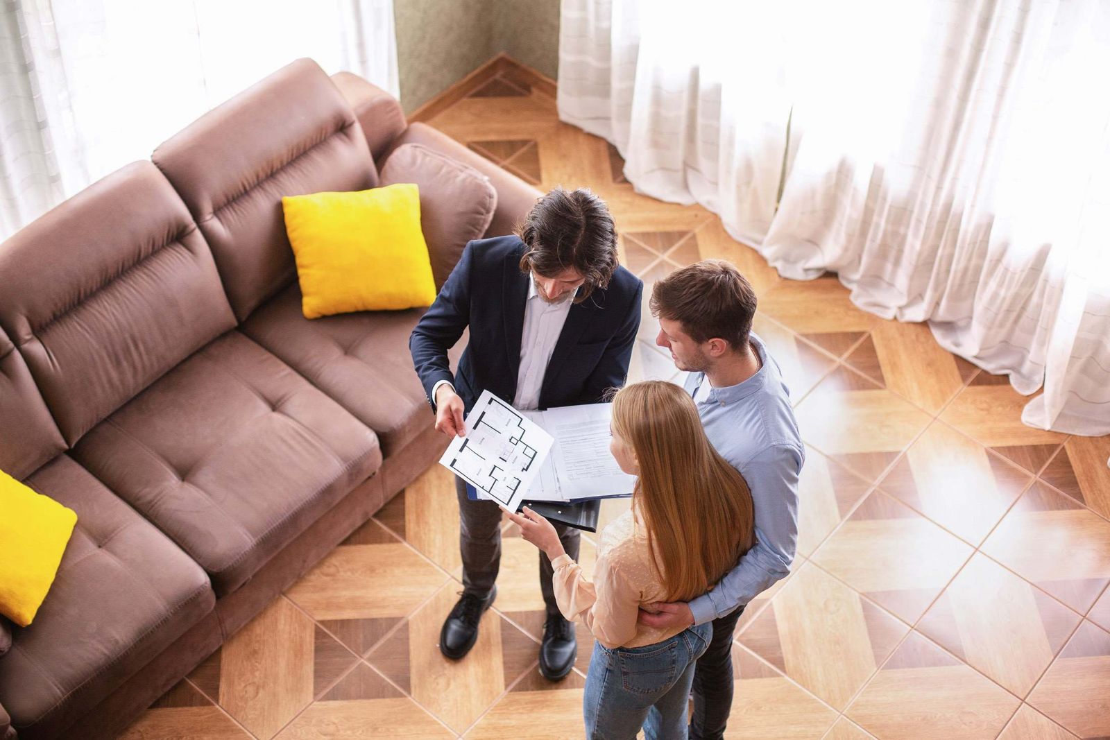 Agent immobilier présentant un plan à des acheteurs